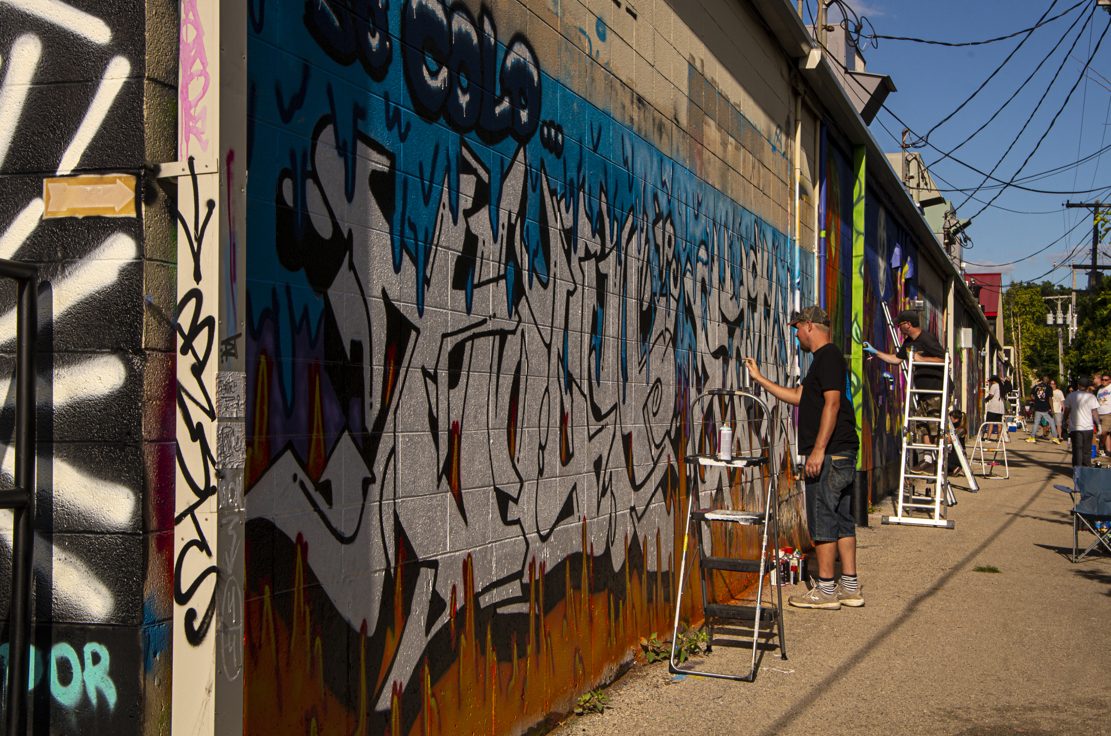 Street artists working on their paintings during Momentum Urban Art Fest.