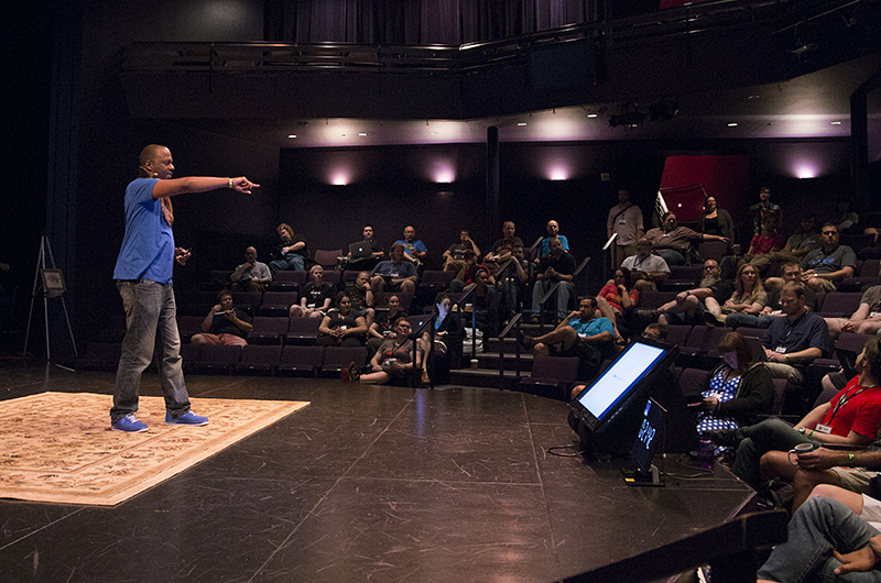 Male speaker surrounded by audience