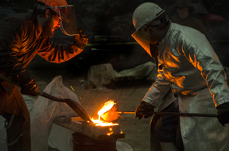 2 people pouring iron